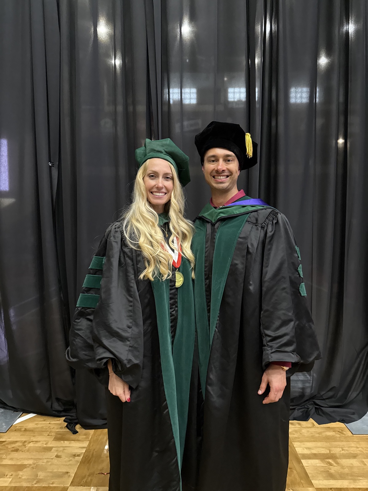 Dr. Alexander Reid with his sister Elise in graduation regalia at her medical school commencement